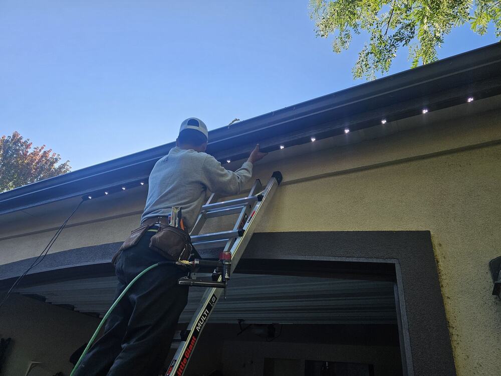 Bosso installer mounting lighting track under a roof eave